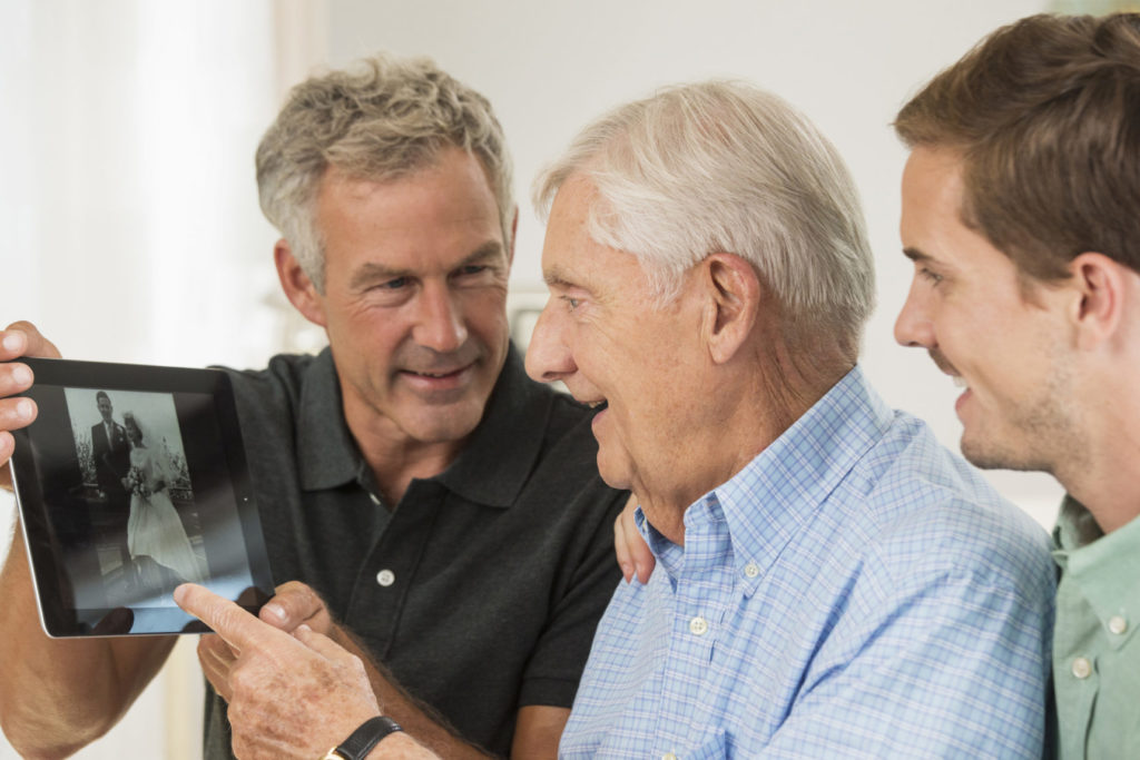 Three generations of Caucasian men using digital tablet