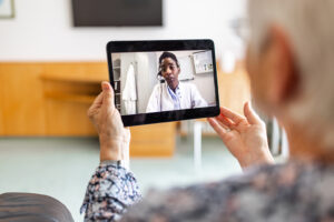 Sick woman at home video conferencing with doctor using digital tablet. Senior female patient having online consultation with her doctor. Telehealth