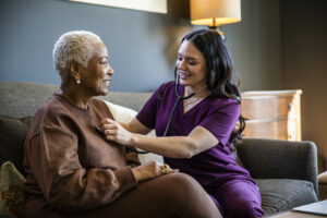 Nurse checking senior woman's vital signs in her home