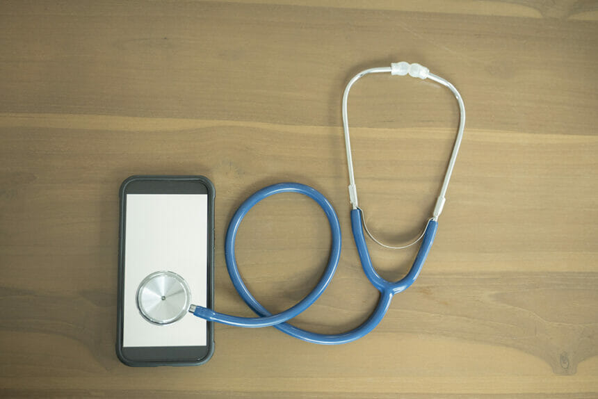 Smartphone and Stethoscope on table.