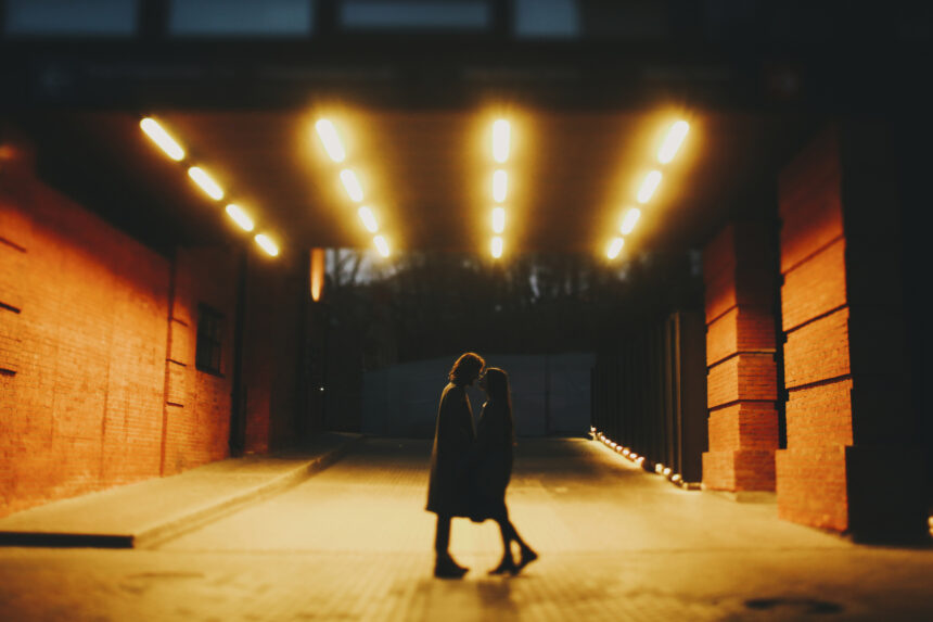 Caucasian couple standing on street in tunnel