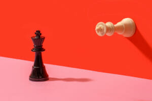 Two king chess pieces on a colored background