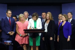 Iowa Gov. Kim Reynolds, a Republican, signs into law a bill that will ban most abortions after around six weeks of pregnancy during a visit to the Family Leadership Summit on July 14 in Des Moines, Iowa. Source: Getty Images.