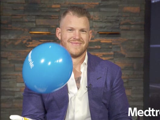 Former NFL star Kyle Rudolph juggles a blue balloon for Medtronic