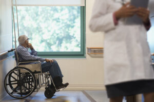 Elderly man sitting in wheelchair in hospital