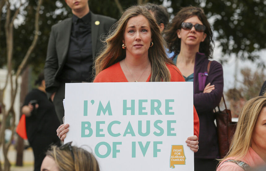 Sarah Brown holds a sign in support of IVF treatments