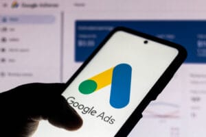 Hand holding smart phone displaying Google Ads screen