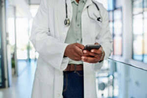 Shot of a male doctor using a smartphone in a hospital